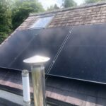Solar panels installed on a cottage slate roof in Llandeilo, South Wales, on a sunny day